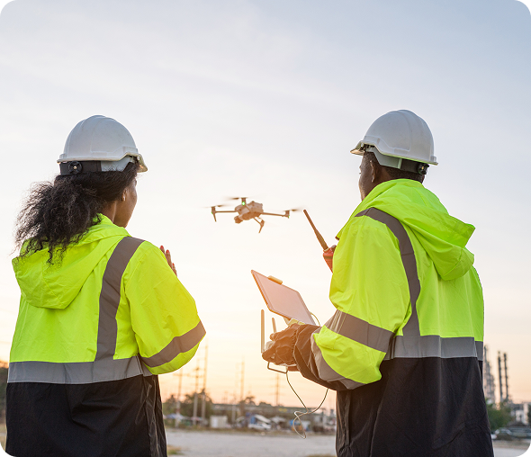 Team of Engineer Specialists Pilot Drone on Construction Site